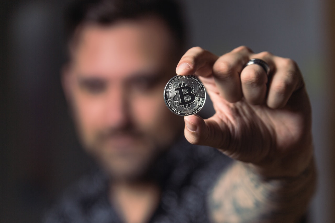 person-holding-silver-bitcoin-coin